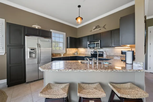 a kitchen with refrigerator and chairs