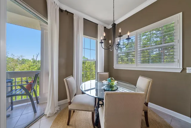 a dining room with furniture a floor to ceiling window and wooden floor