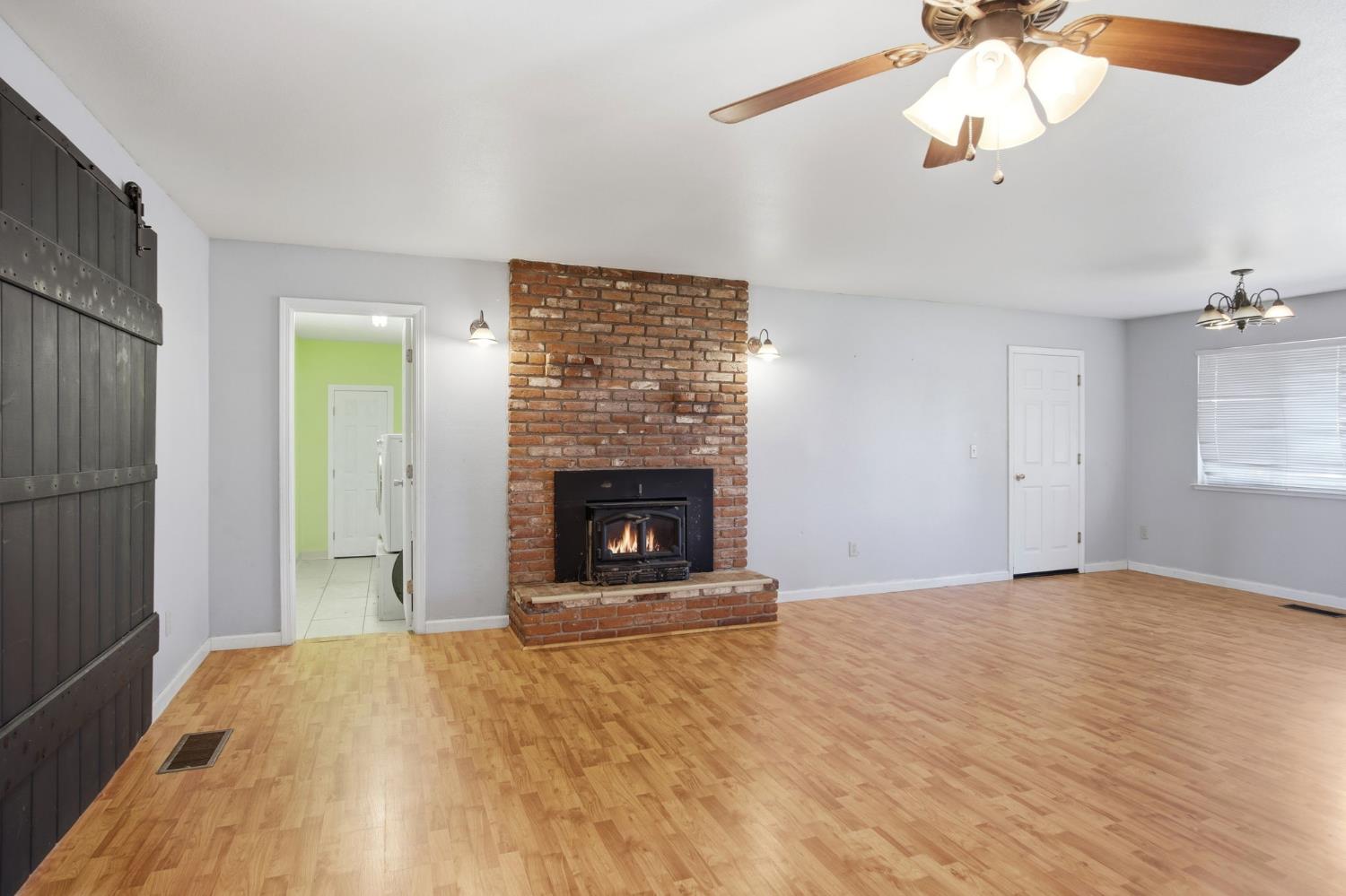1409 Stonum Road Modesto, CA 95351 - Photo 12 of 40 a view of an empty room with a window and fireplace