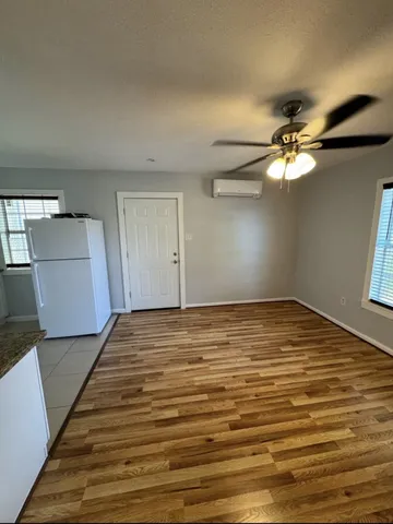 a view of a room with wooden floor and ceiling fan