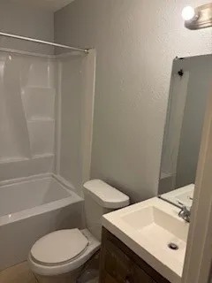 a white toilet sitting next to a bath tub