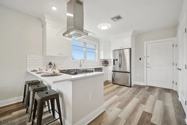 a kitchen with a sink stainless steel appliances and white cabinets