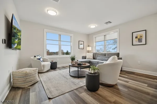 a living room with furniture a flat screen tv and a window