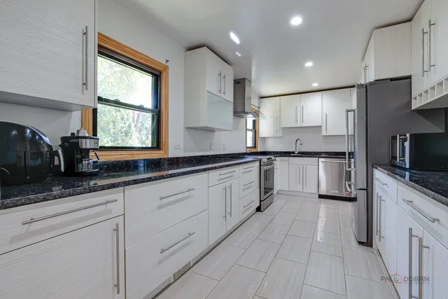 a large kitchen with stainless steel appliances lots of counter space sink and cabinets