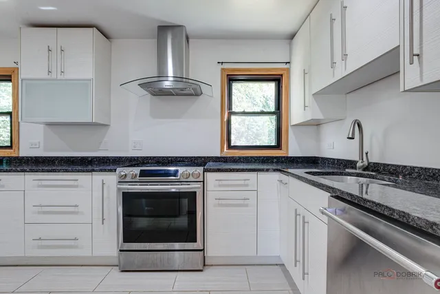 a kitchen with granite countertop a stove sink and cabinets