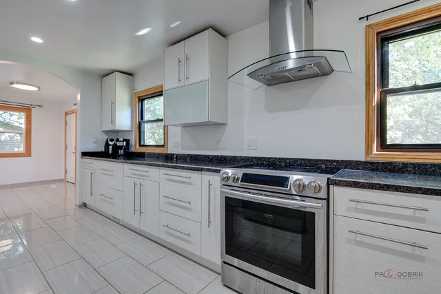 a kitchen with stainless steel appliances granite countertop a stove a sink and a microwave