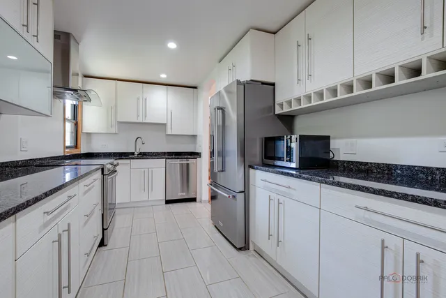 a kitchen with stainless steel appliances granite countertop a refrigerator sink and cabinets
