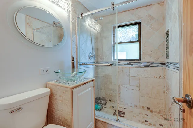 a bathroom with a granite countertop sink a mirror and shower