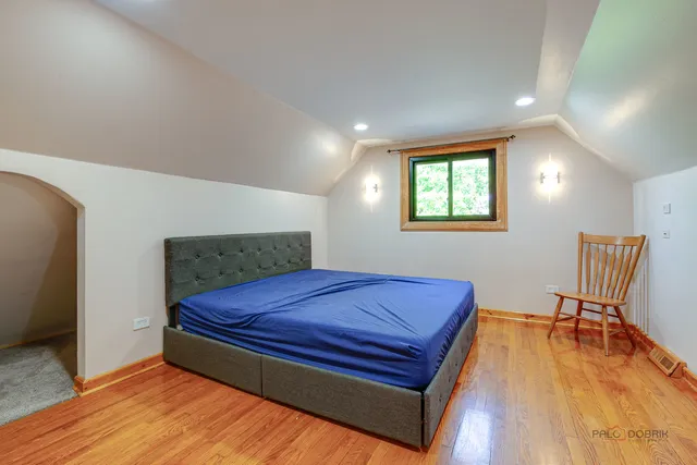 a bedroom with a bed and wooden floor