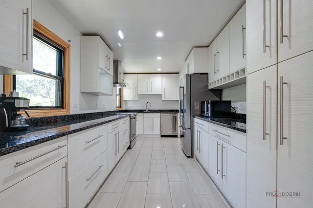 a large kitchen with stainless steel appliances lots of counter space and a sink