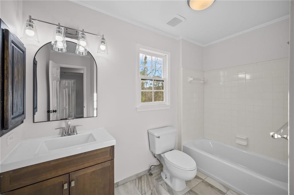 2250 Chickering Court Cumming, GA 30041 - Photo 16 of 25 a bathroom with a toilet a sink and a bathtub