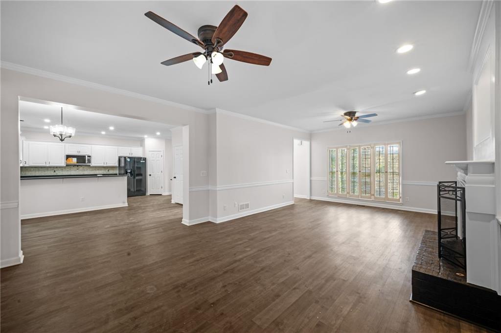 2250 Chickering Court Cumming, GA 30041 - Photo 9 of 25 a view of an empty room with wooden floor and a kitchen
