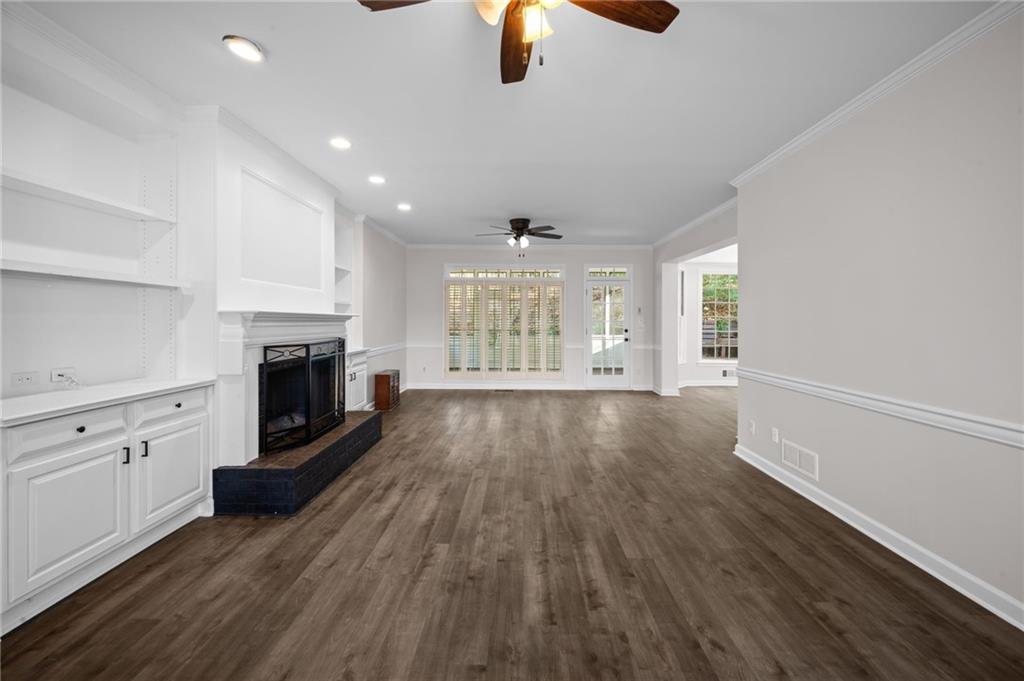 2250 Chickering Court Cumming, GA 30041 - Photo 10 of 25 an empty room with wooden floor fireplace and windows