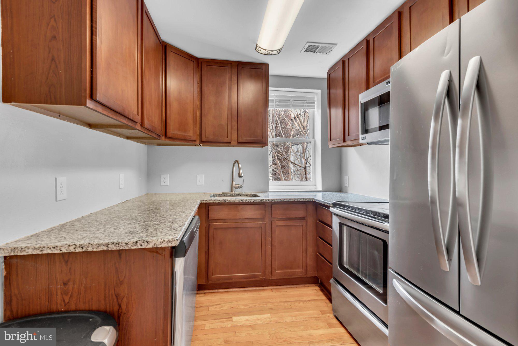 210 West Read Street Baltimore, MD 21201 - Photo 4 of 11 a kitchen with stainless steel appliances granite countertop a refrigerator sink and cabinets