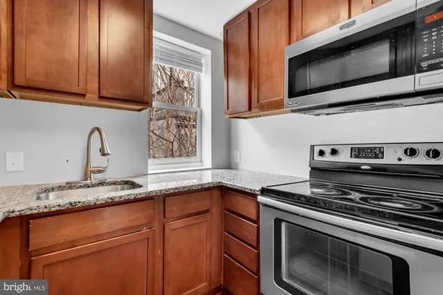 a kitchen with stainless steel appliances granite countertop a sink stove and microwave