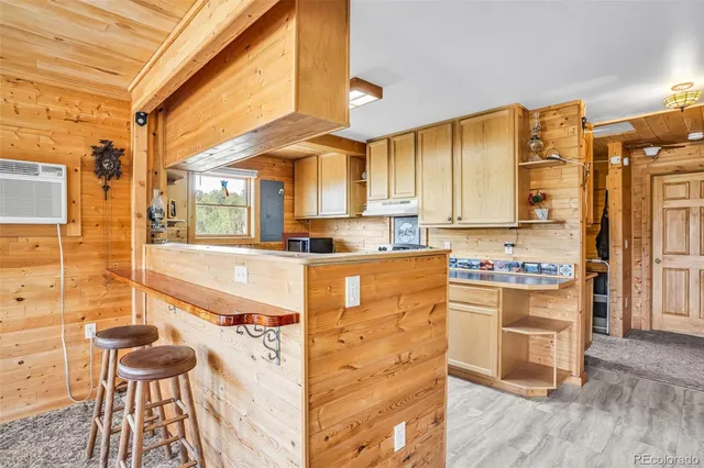 a kitchen with granite countertop wooden cabinets and a stove top oven