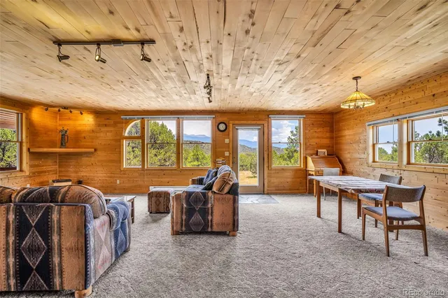 a view of a dining room with furniture large windows and wooden floor