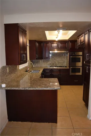 a kitchen with granite countertop cabinets and steel stainless steel appliances