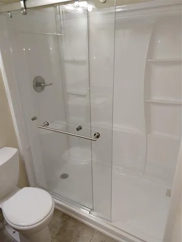a bathroom with a toilet and a shower