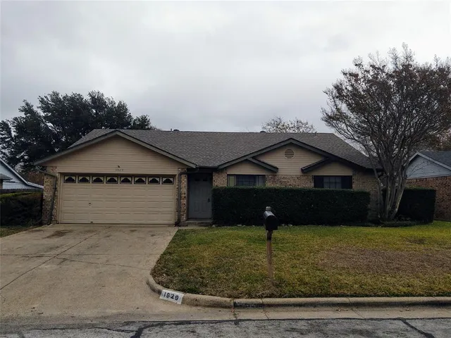 a view of a house with a yard and large tree