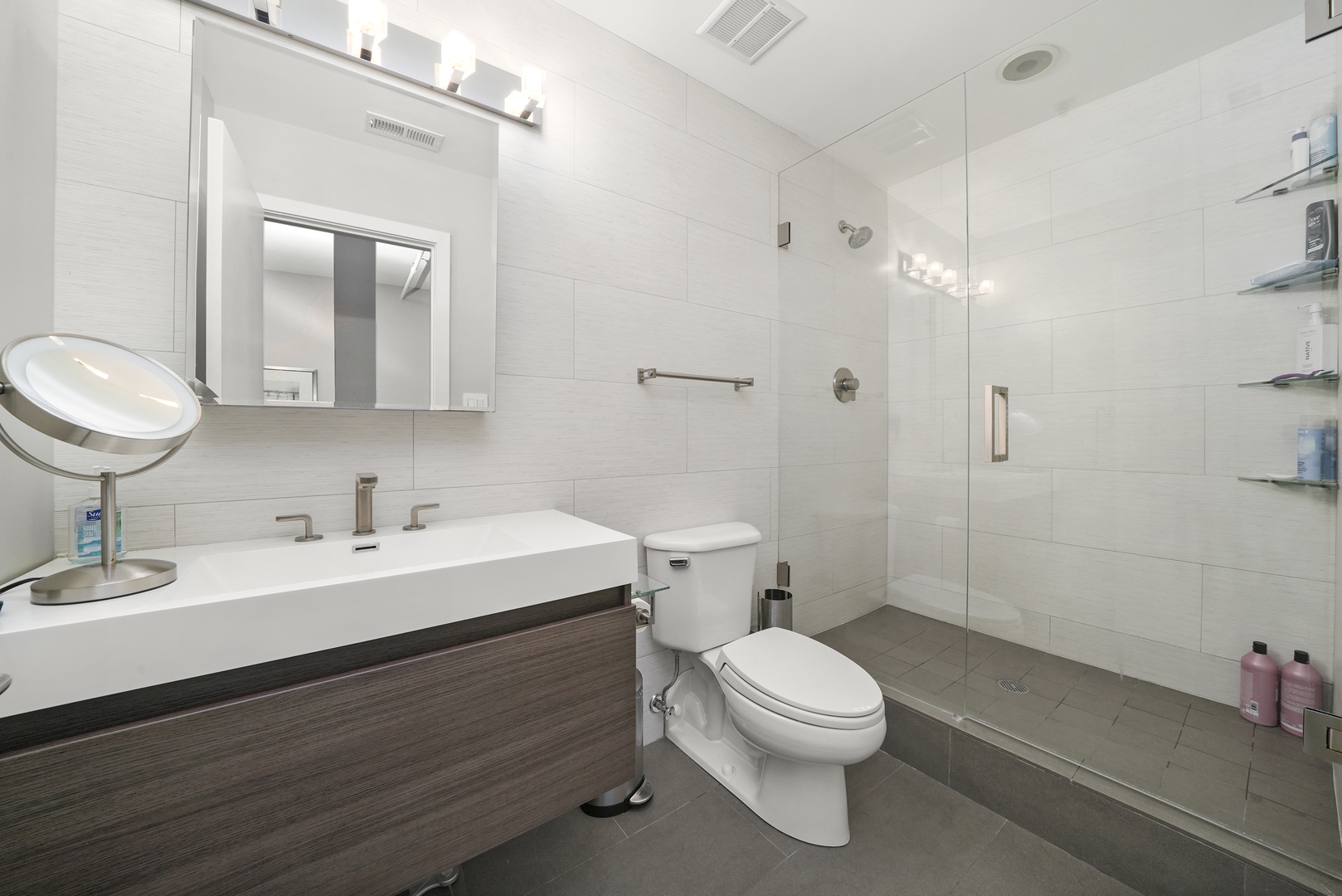 360 West Illinois Street, Unit 614 Chicago, IL 60654 - Photo 14 of 36 a bathroom with a toilet a sink a mirror and a shower