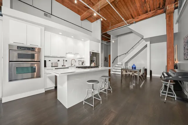 a kitchen with a table chairs refrigerator and cabinets
