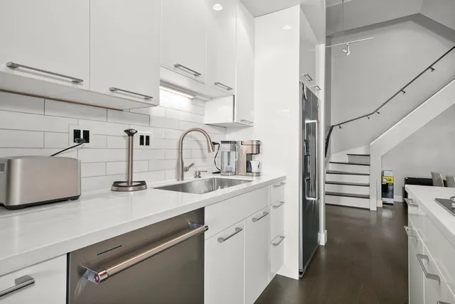 a kitchen with white cabinets and appliances