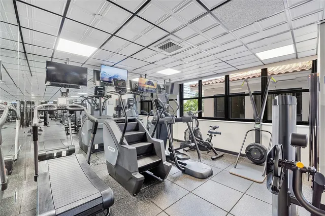 a room with gym equipment and lots of wooden floor