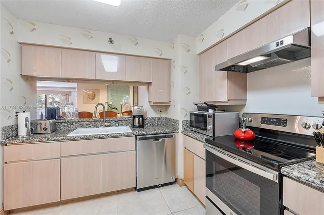 a kitchen with stainless steel appliances granite countertop a sink and cabinets