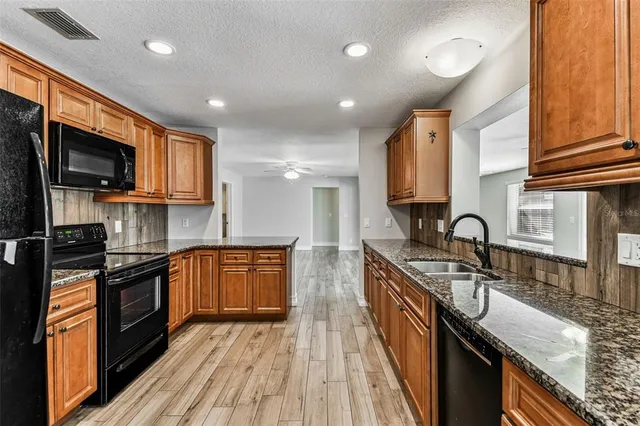 a view of a big room with wooden floor and a kitchen