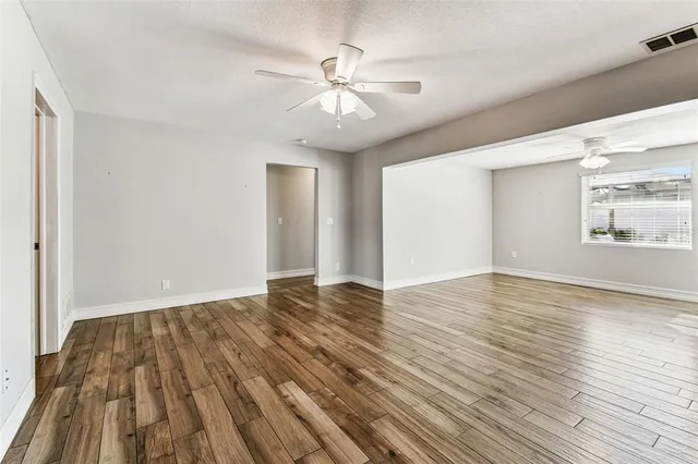 a view of a hallway with wooden floor and entryway
