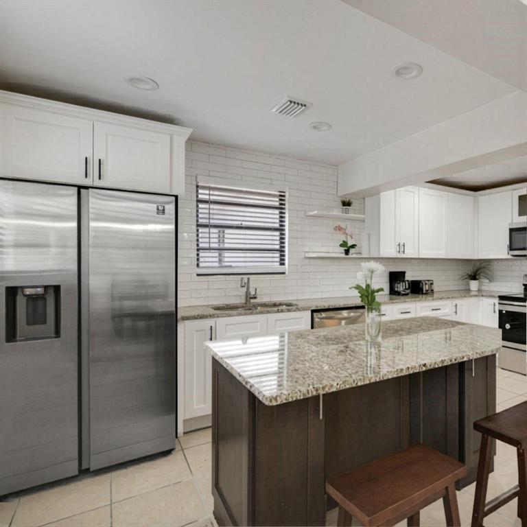 1202 Princeton Road Cocoa, FL 32922 - Photo 12 of 15 a kitchen with stainless steel appliances granite countertop a refrigerator a sink a stove a microwave and island