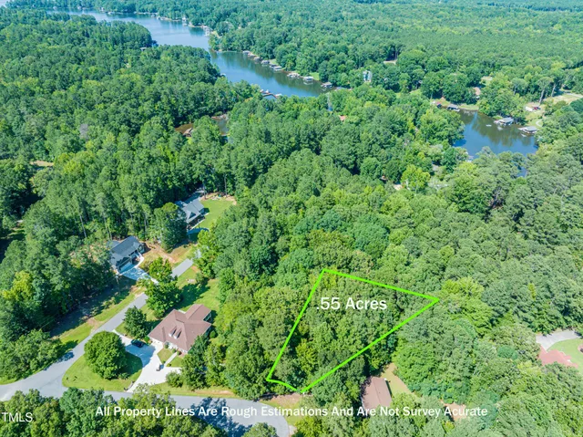 an aerial view of residential house with outdoor space and trees all around