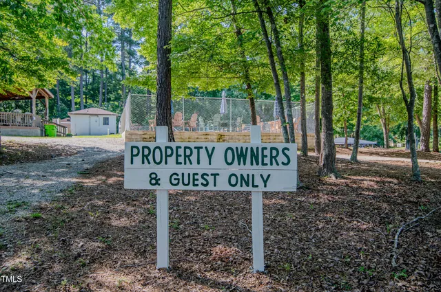 a view of a roof deck with table and chairs a barbeque with wooden floor and fence