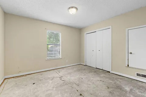a view of a big room with closet and windows