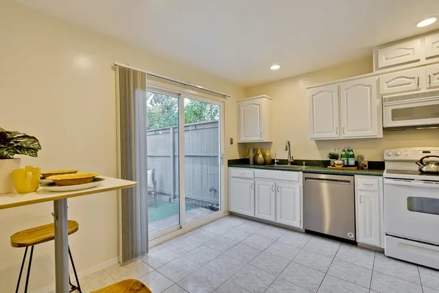 a kitchen with stainless steel appliances granite countertop a stove a sink and a refrigerator
