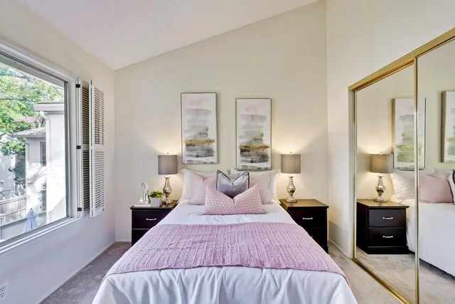 a bedroom with a bed and a large mirror