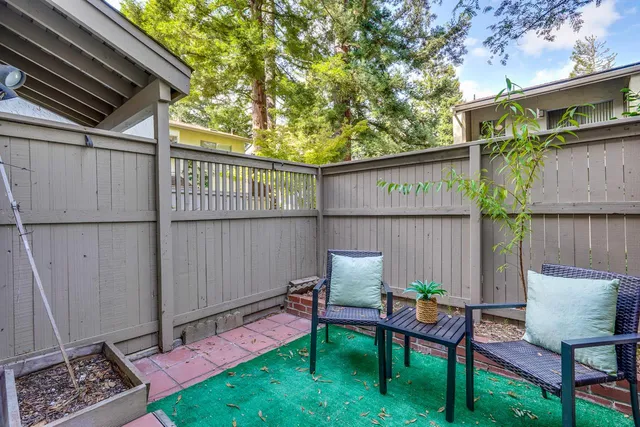a view of a patio with couple of chairs and a potted plant