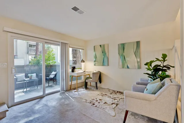 a living room with furniture a window and a potted plant