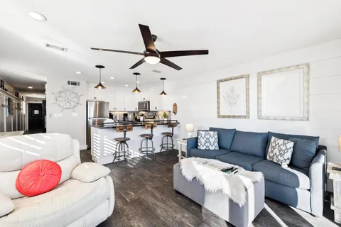 a living room with furniture and view of kitchen