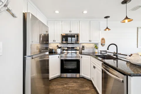 a kitchen with stainless steel appliances granite countertop a stove a sink and a refrigerator