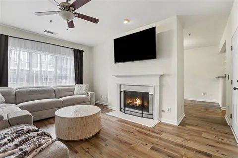 a living room with furniture a flat screen tv and a fireplace
