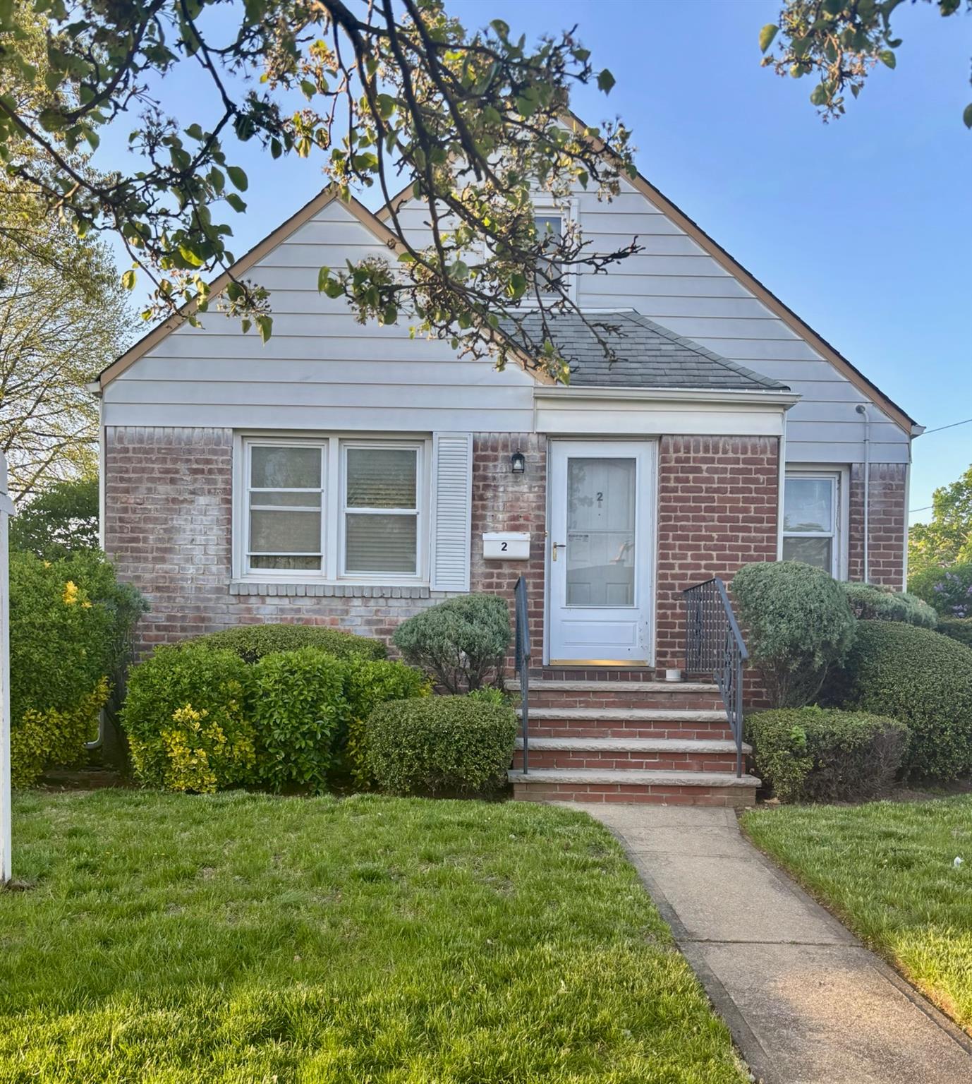 a front view of a house with a garden