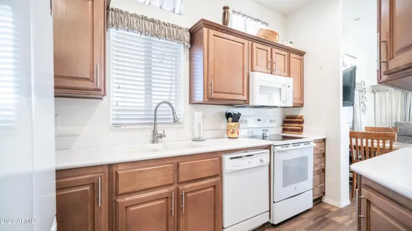 a kitchen with white cabinets a sink and white appliances