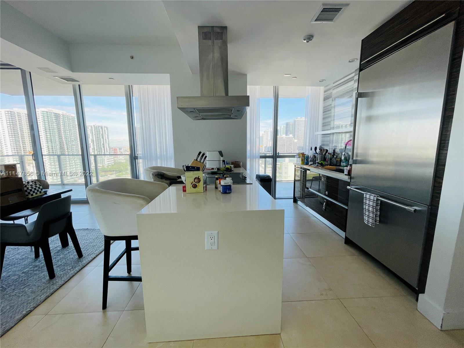 1100 Biscayne Boulevard, Unit 2003 Miami, FL 33132 - Photo 3 of 24 a kitchen with stainless steel appliances granite countertop a sink a stove and refrigerator