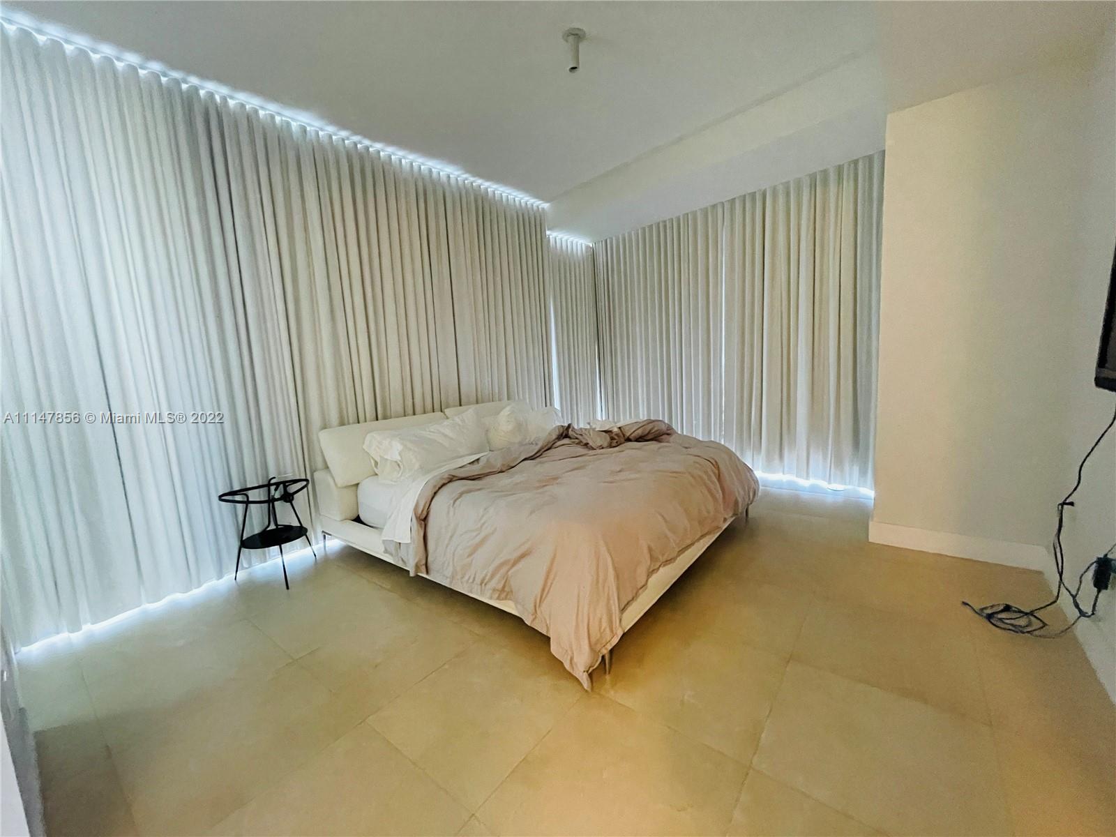 1100 Biscayne Boulevard, Unit 2003 Miami, FL 33132 - Photo 7 of 24 a bed sitting in a spacious bedroom next to a window