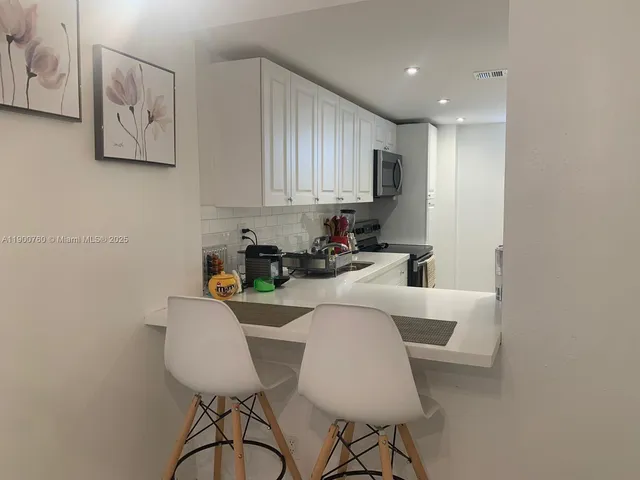 a kitchen with a refrigerator and a sink