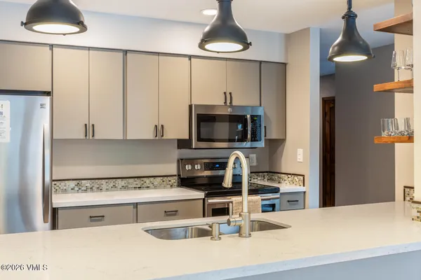 a kitchen with stainless steel appliances a stove a sink and a microwave