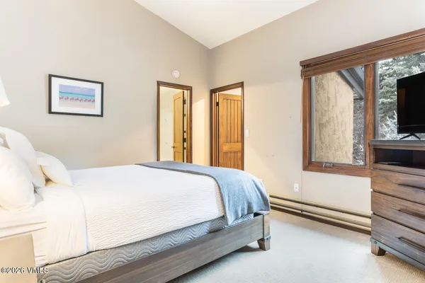 a bedroom with a bed and a flat tv screen