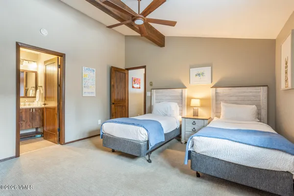 a spacious bedroom with a bed and a lamp
